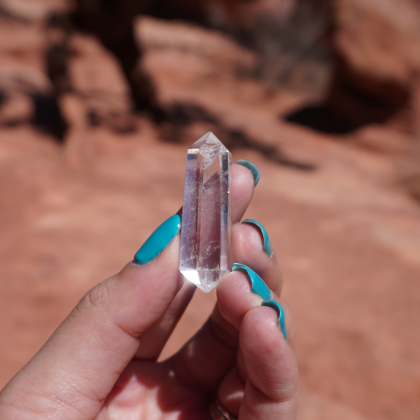 Clear quartz crystal in hand, highlighting size, clarity, and hexagonal formation.