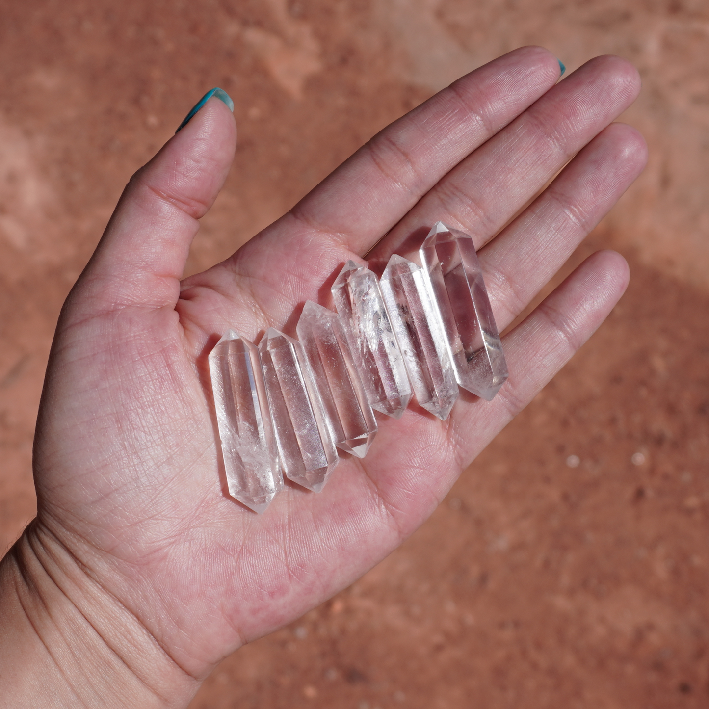 Palm full of double terminated clear quartz points, ideal for ritual use, gridding, or spiritual cleansing.