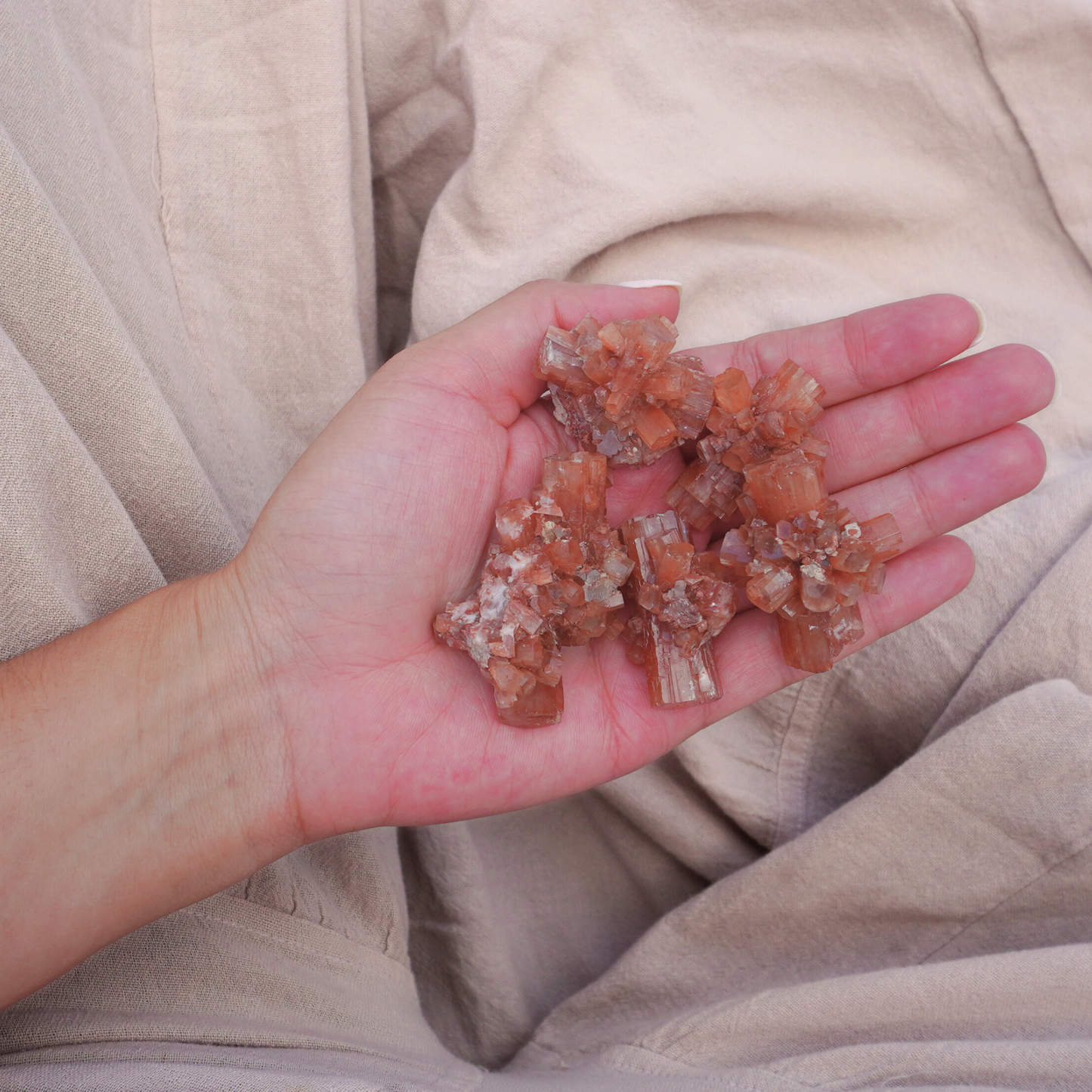 Close-up of a hand holding a Raw Aragonite Crystal, showing the intricate natural structure and high-energy properties.