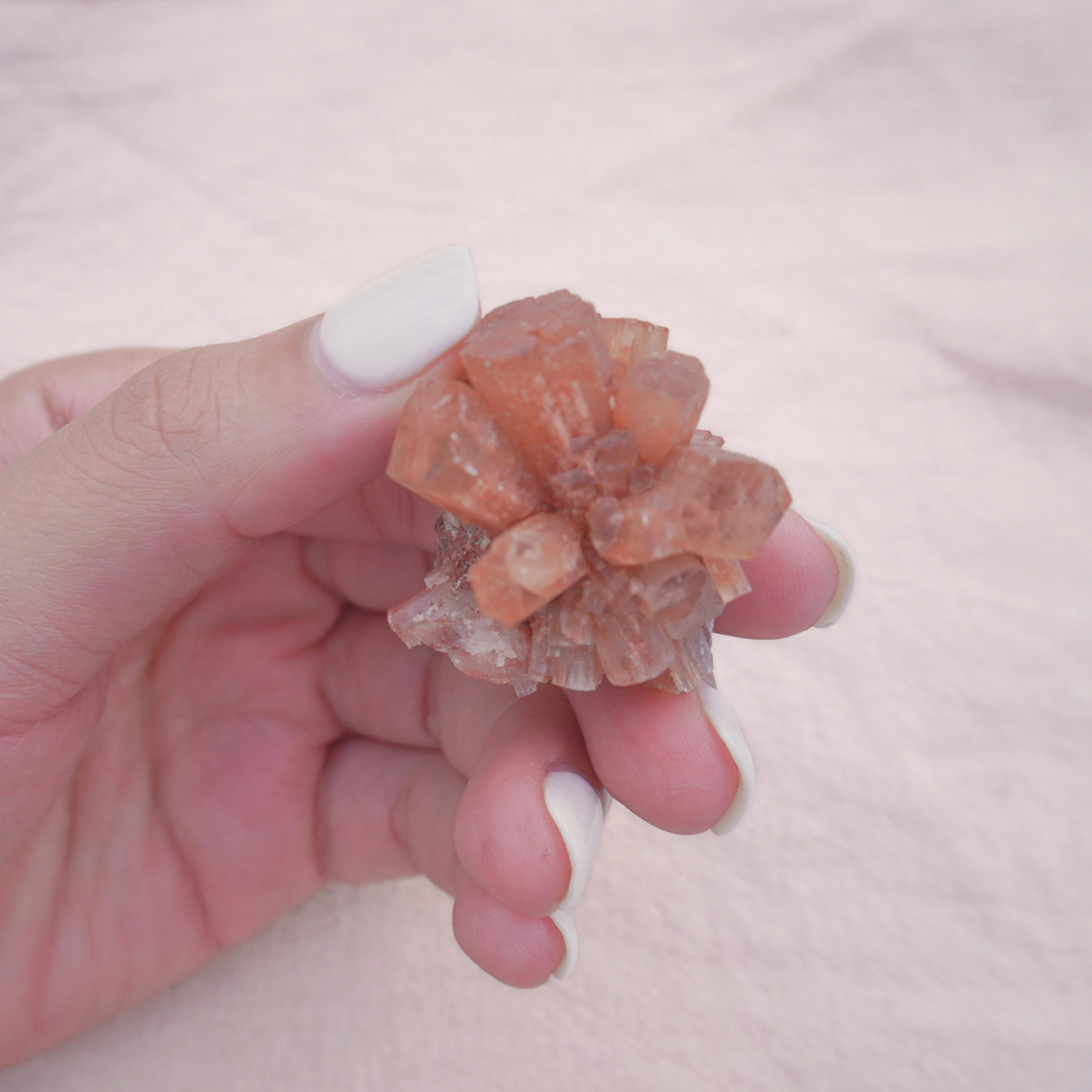 A hand gently holding a powerful Aragonite Cluster, ideal for meditation, energy work, and emotional balance.