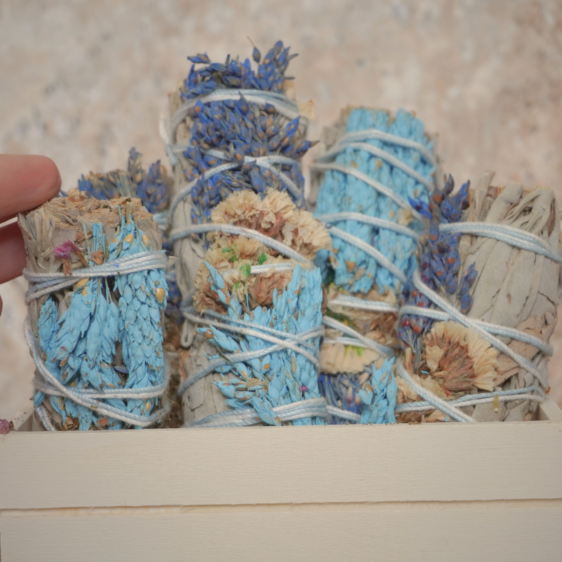 A curated selection of California white sage bundles adorned with sinuata flowers, perfect for spiritual cleansing and meditation. Presented by Sacred Owl Healers.