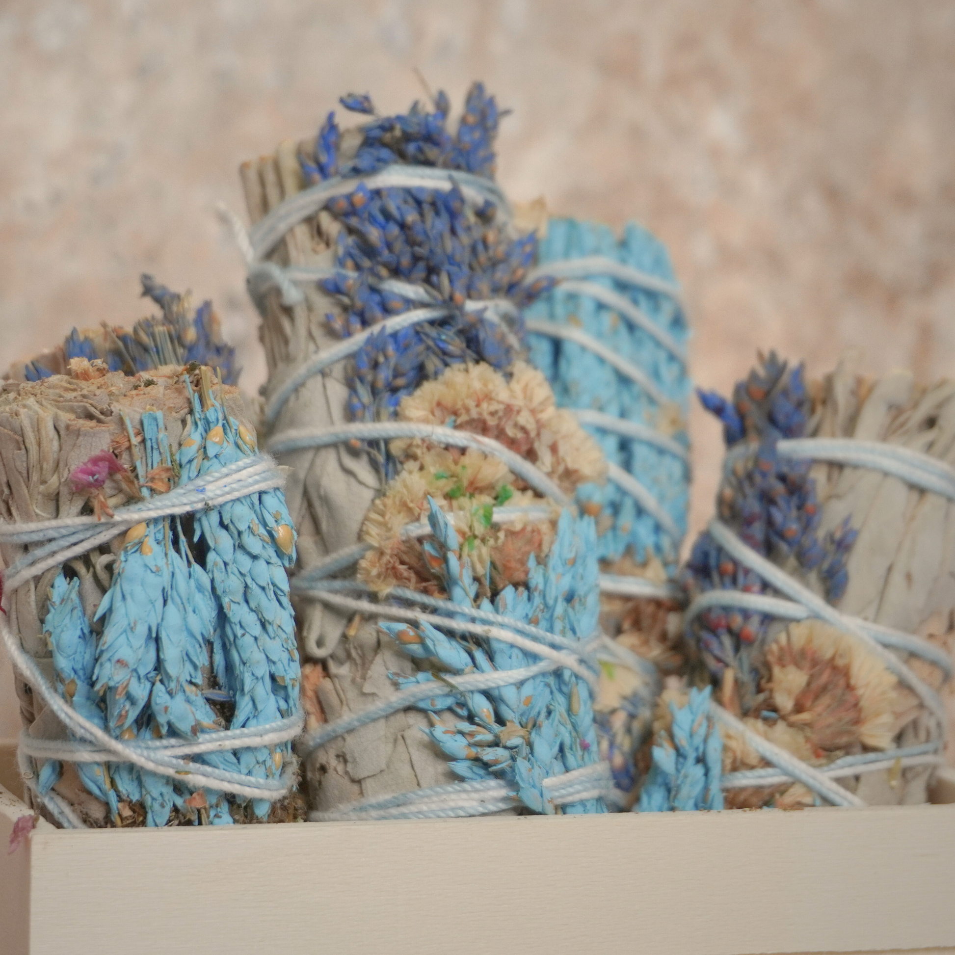 California white sage bundles infused with the beauty of sinuata flowers, wrapped in white string, used for smudging and balancing energy.