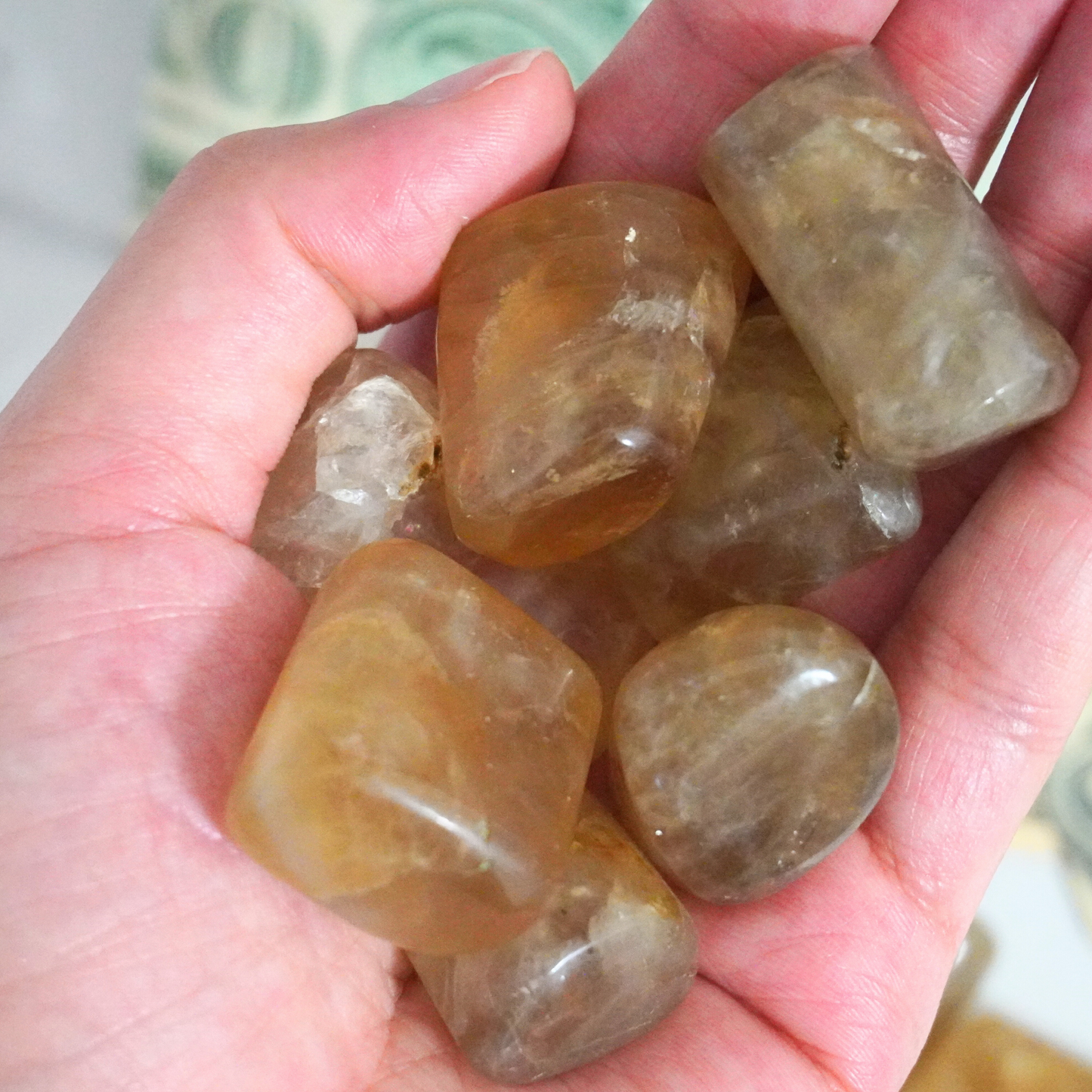 Hand holding a polished Smoky Citrine tumble stone