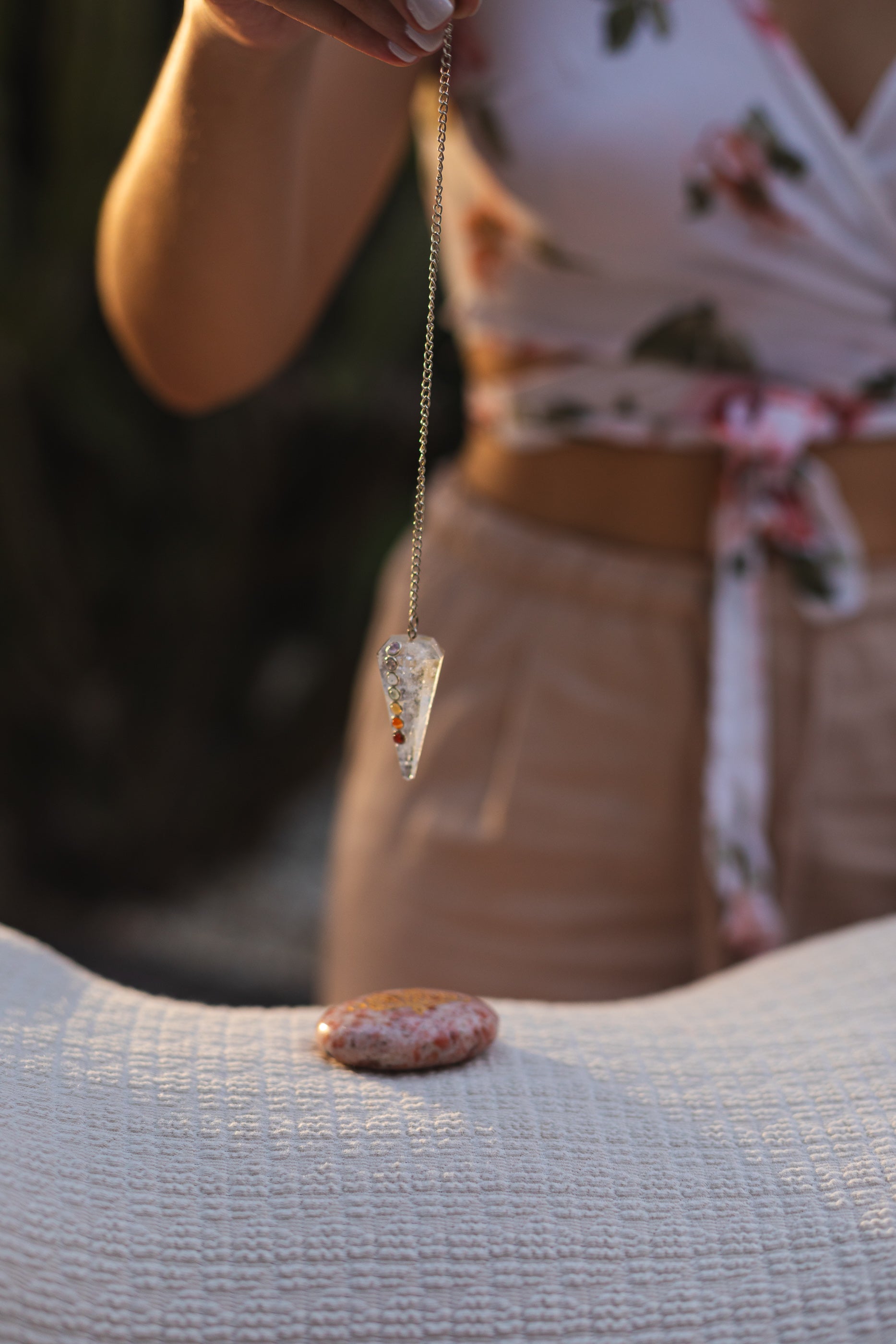 Sacred Owl Healers Crystal healer conducting a Chakra Balancing session in a client’s home, with stones placed on the chakras and a Vogel crystal used for energy extraction.