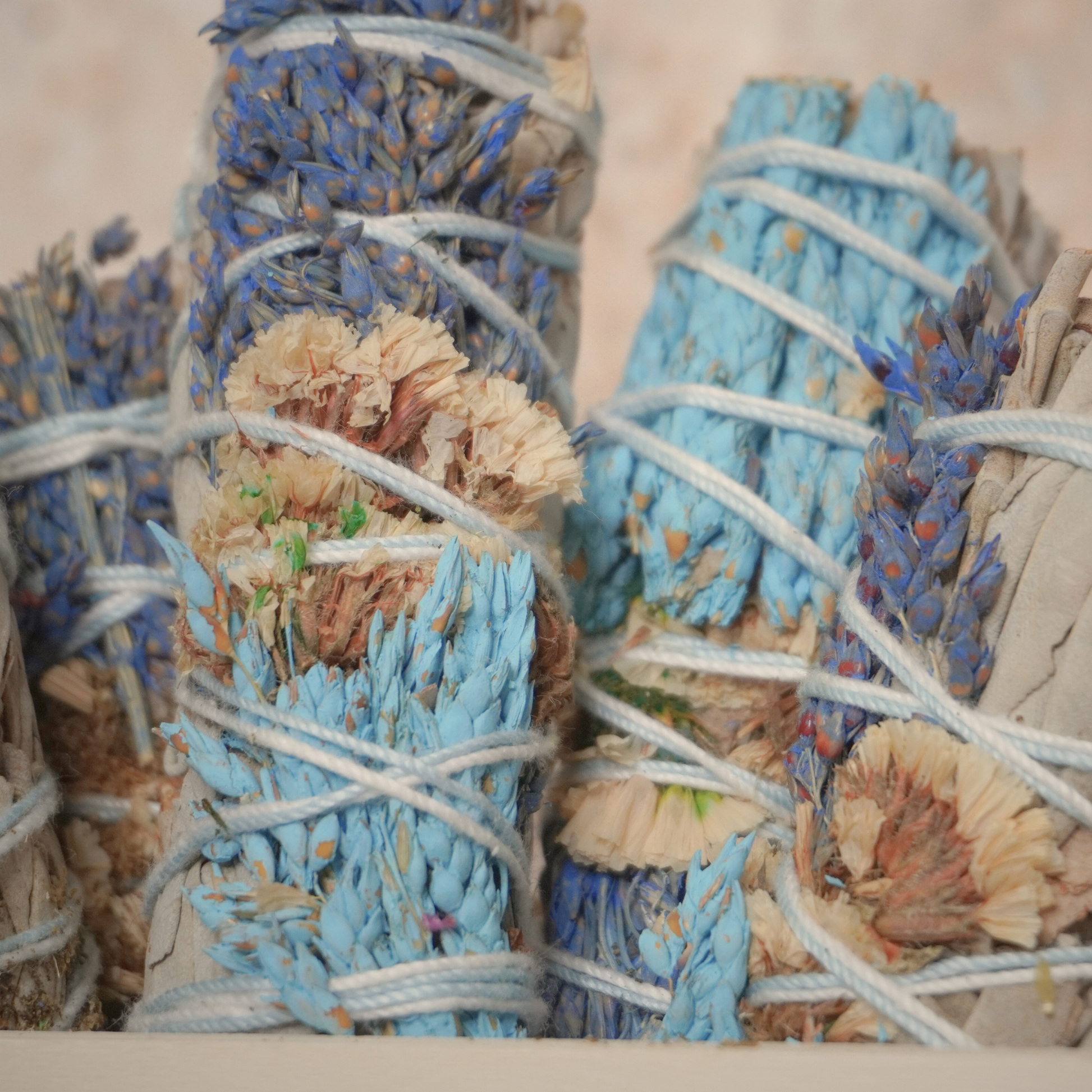 Artfully arranged white sage smudge sticks with sinuata flowers, perfect for energy cleansing and creating peaceful spaces.