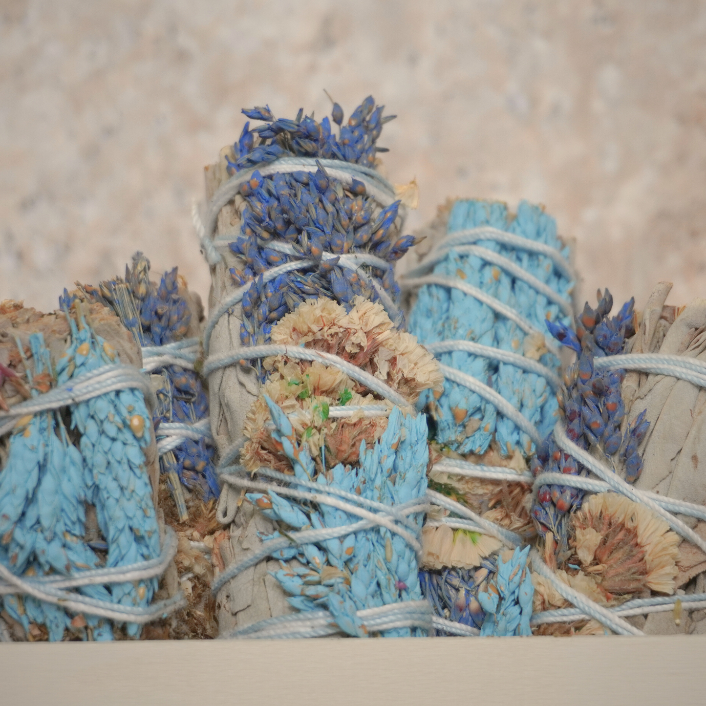 Close-up of sinuata flowers and white sage bundles, highlighting the handcrafted quality and purpose for energy healing.